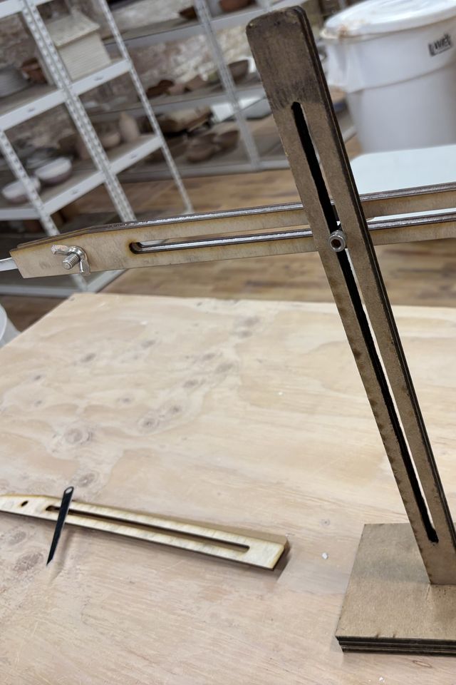 One of the arms is attached to the frame using a bat pin and wing nut.