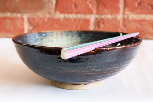 One of the ramen bowls, with chop-sticks sitting across a set of shallow notches in the rim
